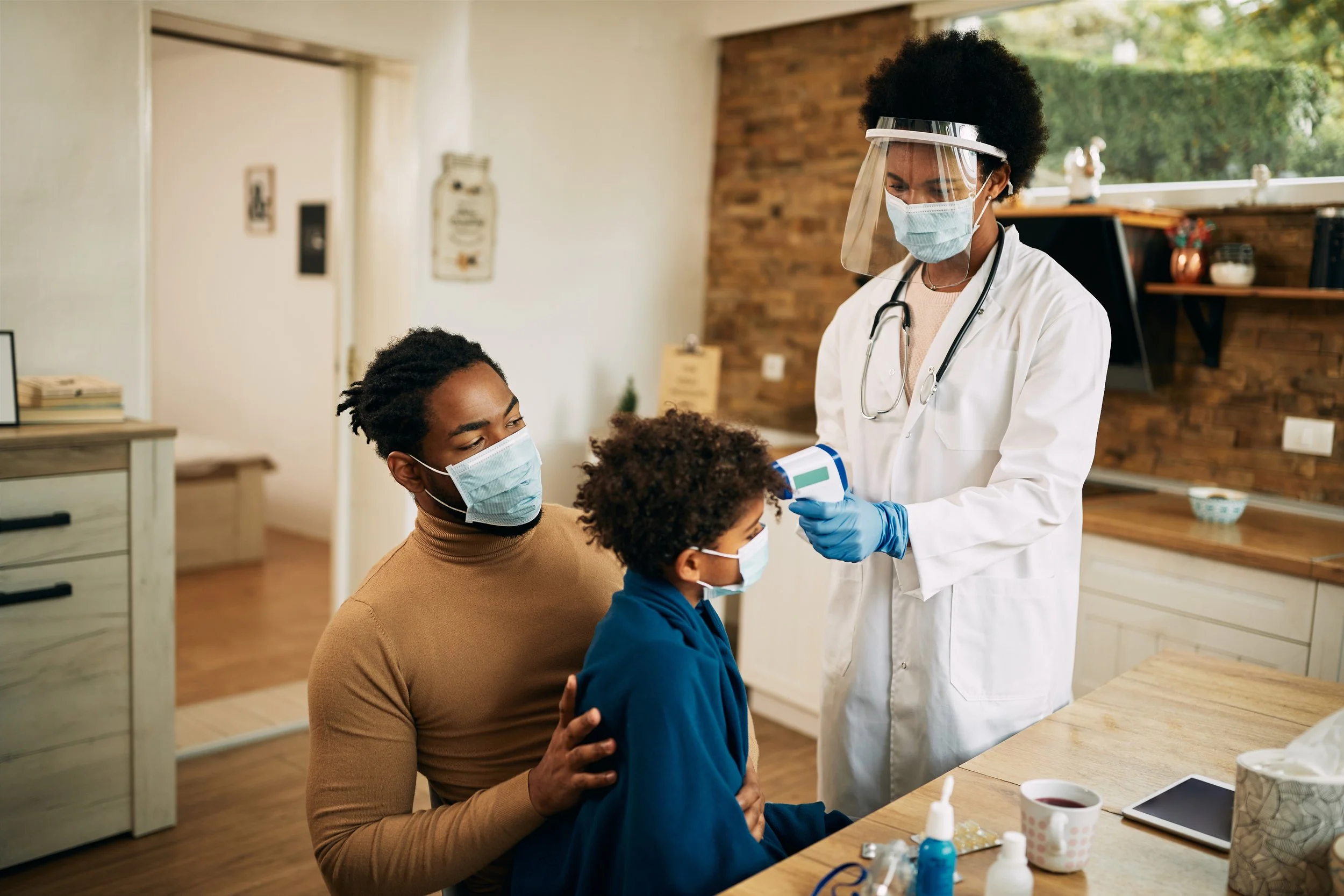 Young doctor in scrubs reviewing medications with a patient at home