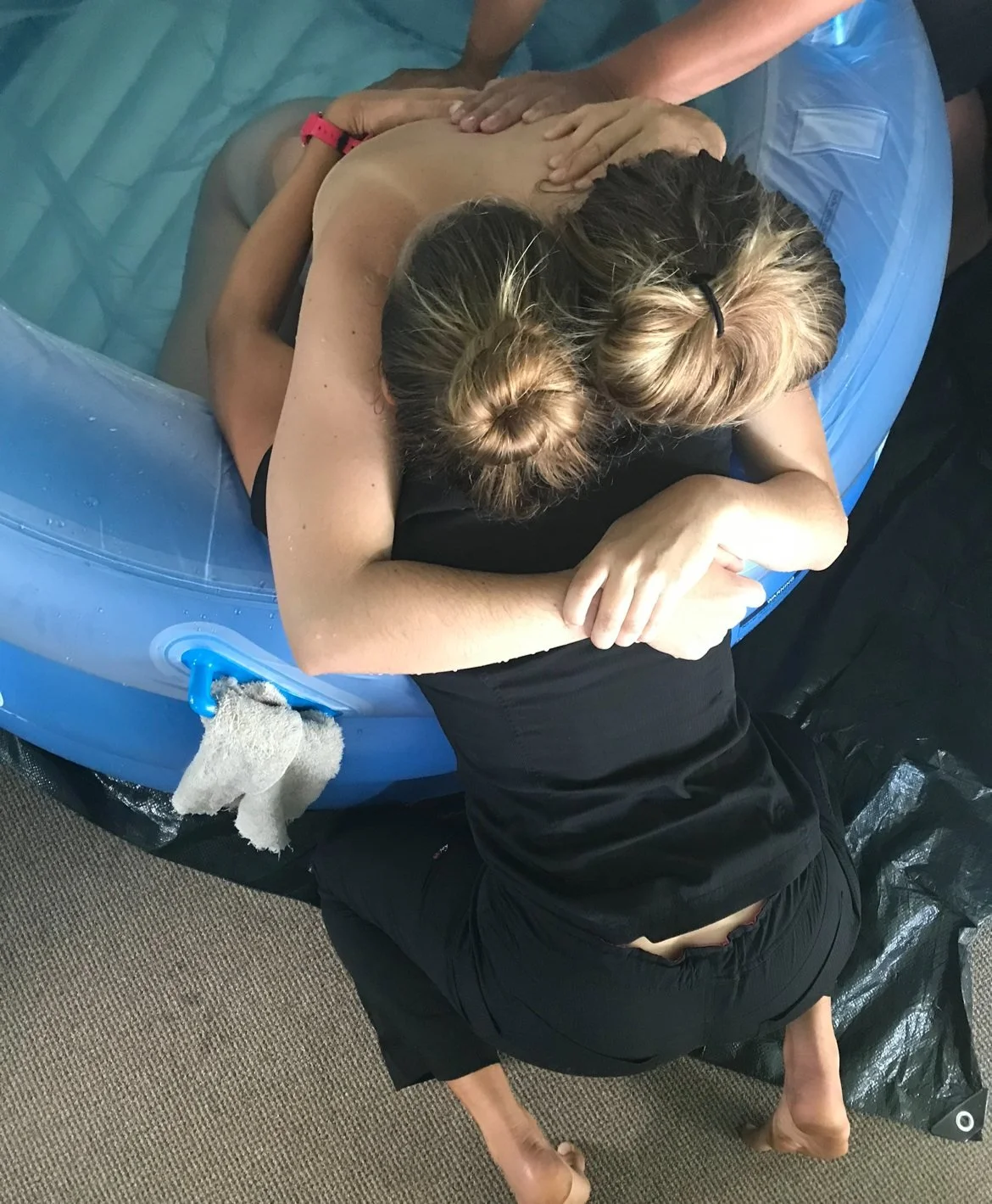 Doula Asia Rideout supporting a laboring mother in a birth pool with counter pressure