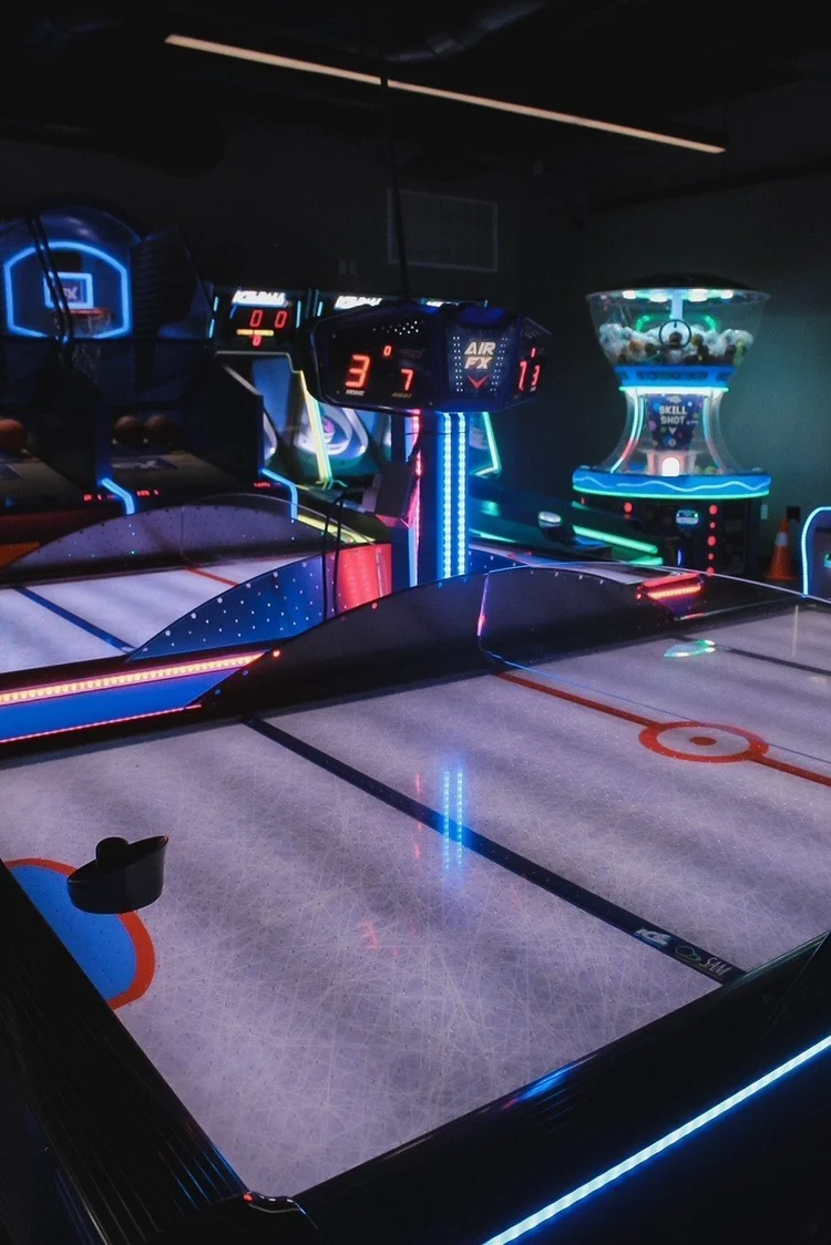 Skee-ball lanes glowing under neon lights in the Silver Stone Castle arcade, Swansea, MA