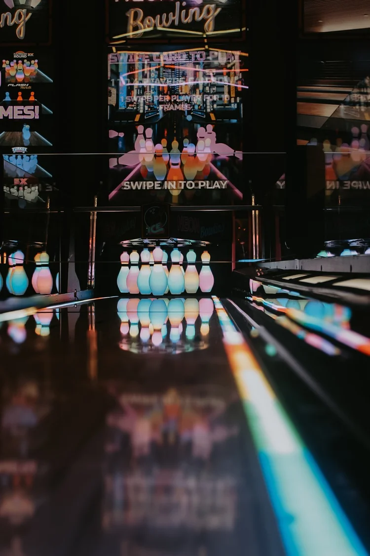 Neon Bowling lanes with glowing pins and Swipe to Play sign at Silver Stone Castle in Swansea, MA