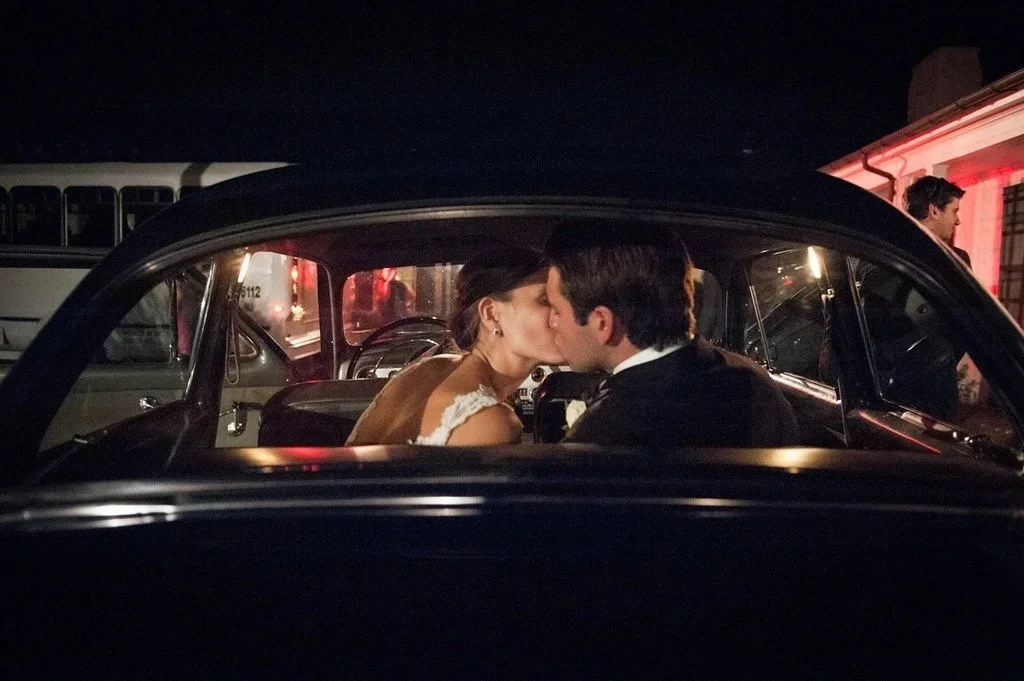 New Jersey wedding photographer capturing a newlywed couple kissing in the back of a vintage getaway car
