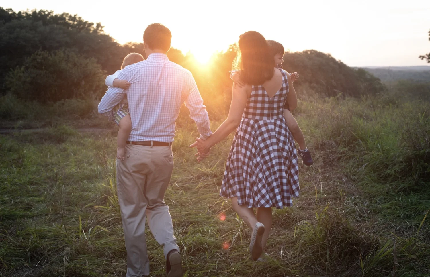 New Jersey family photographer capturing a family of four walking through a field at sunset