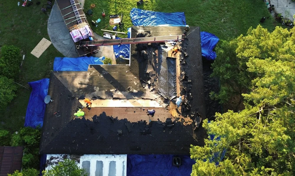 7V crew checking and replacing roof deck boards during a tear-off