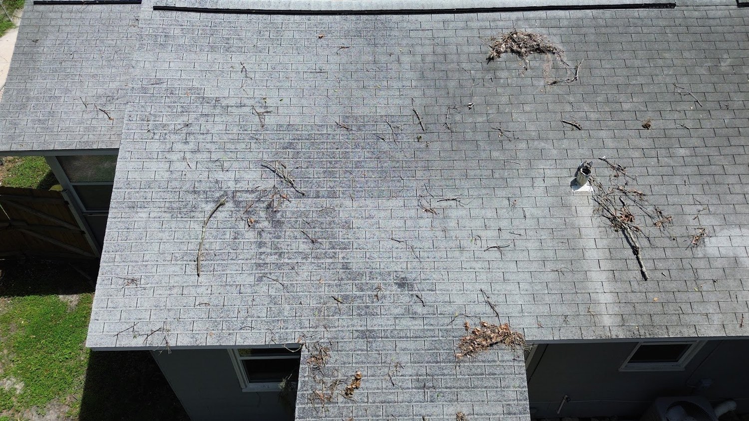 Worn asphalt shingle roof with debris before replacement