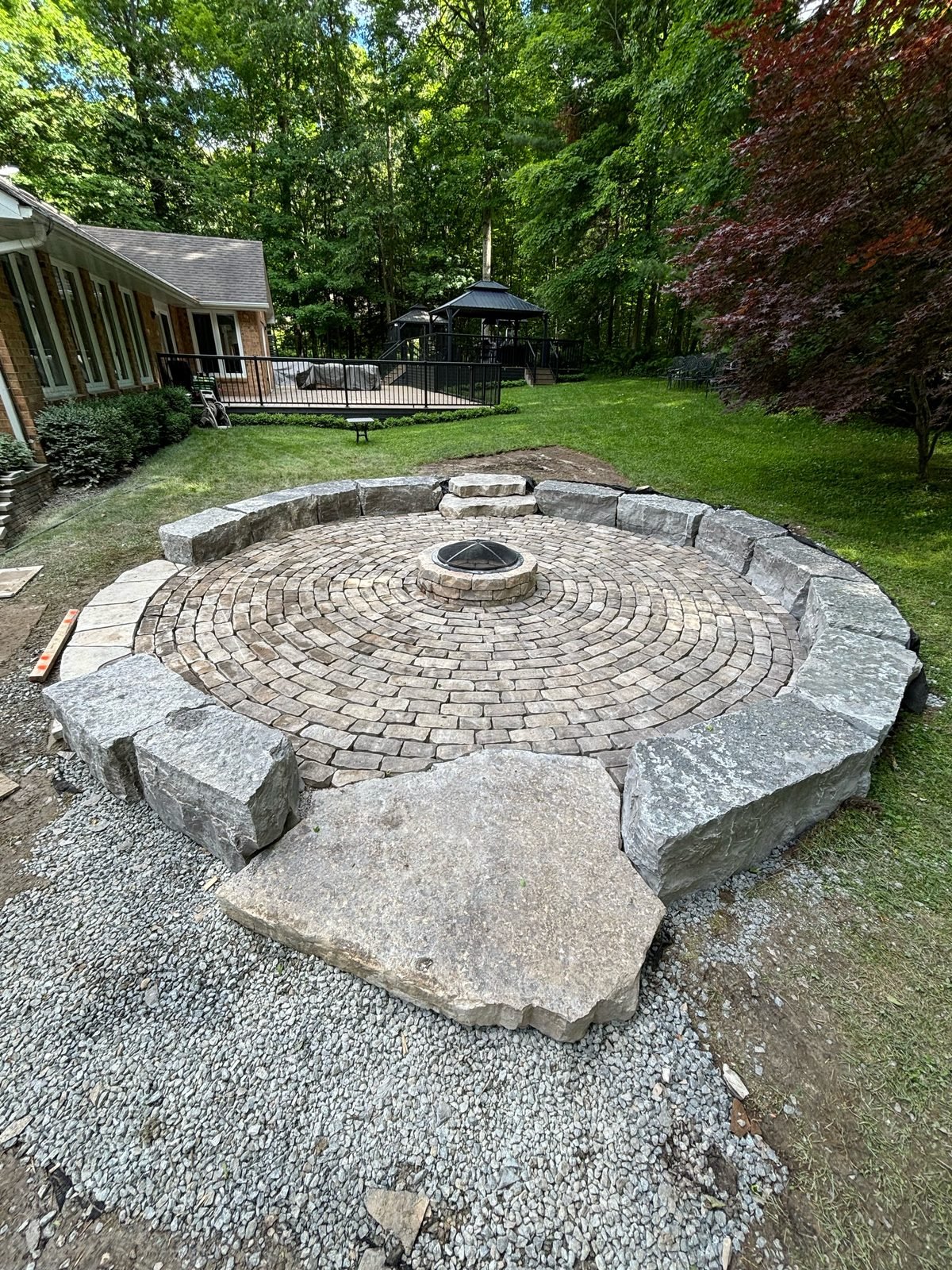 Circular interlock fire pit patio with armour stone seating