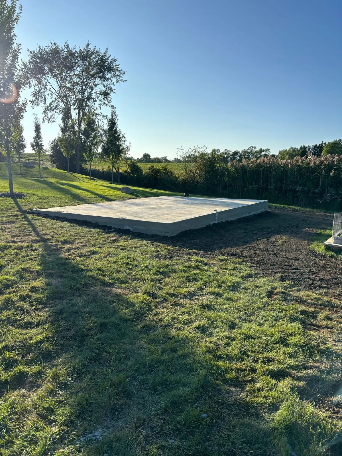 New concrete pad poured in a large lawn