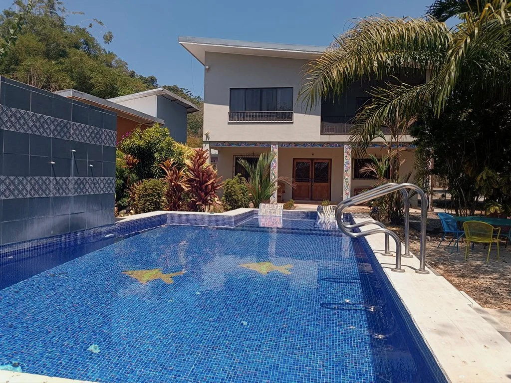 Front view of Hermosa Duplex in Playa Hermosa featuring a private pool, tropical garden, and modern design ideal for vacation rental.