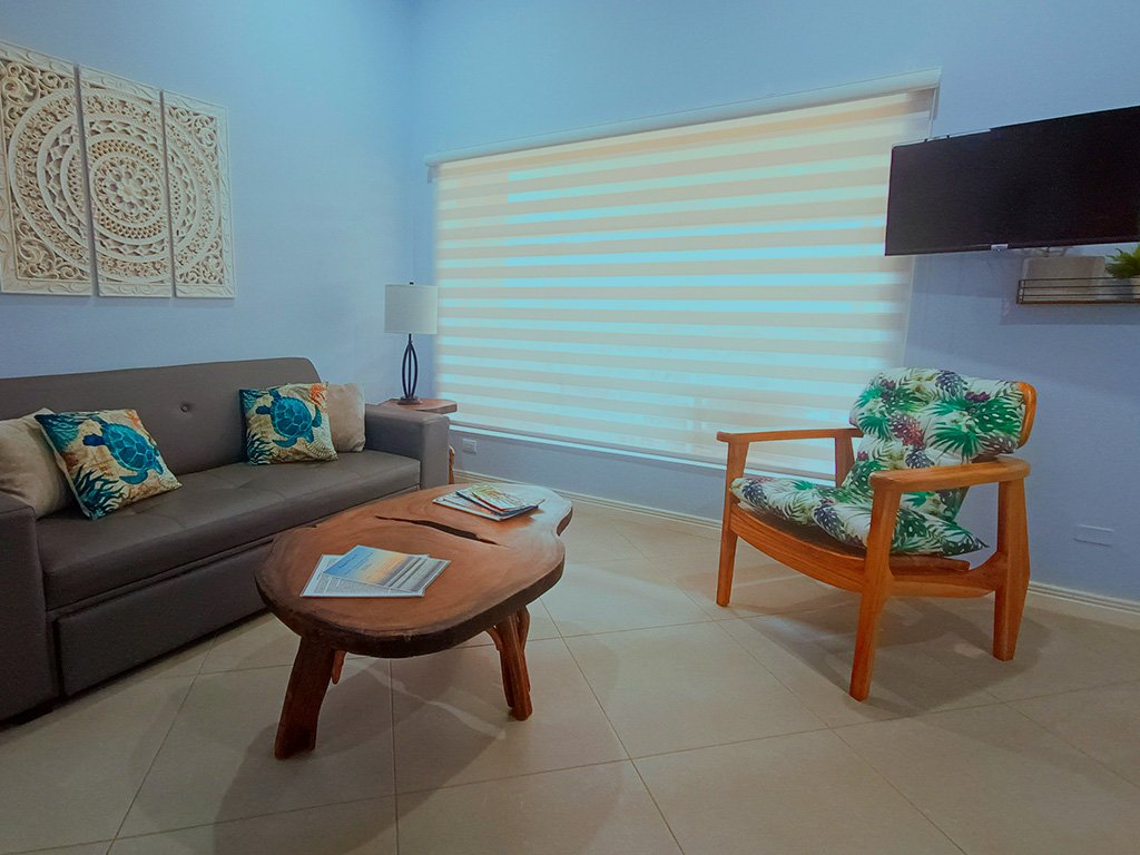 Cozy tropical-style living room with comfortable seating at Beach apartment COCO 49 vacation rental in Jacó, Costa Rica.