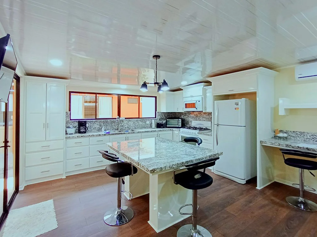 Modern open kitchen with breakfast island and stainless steel appliances at Sol Dorado House vacation rental in Costa Rica.