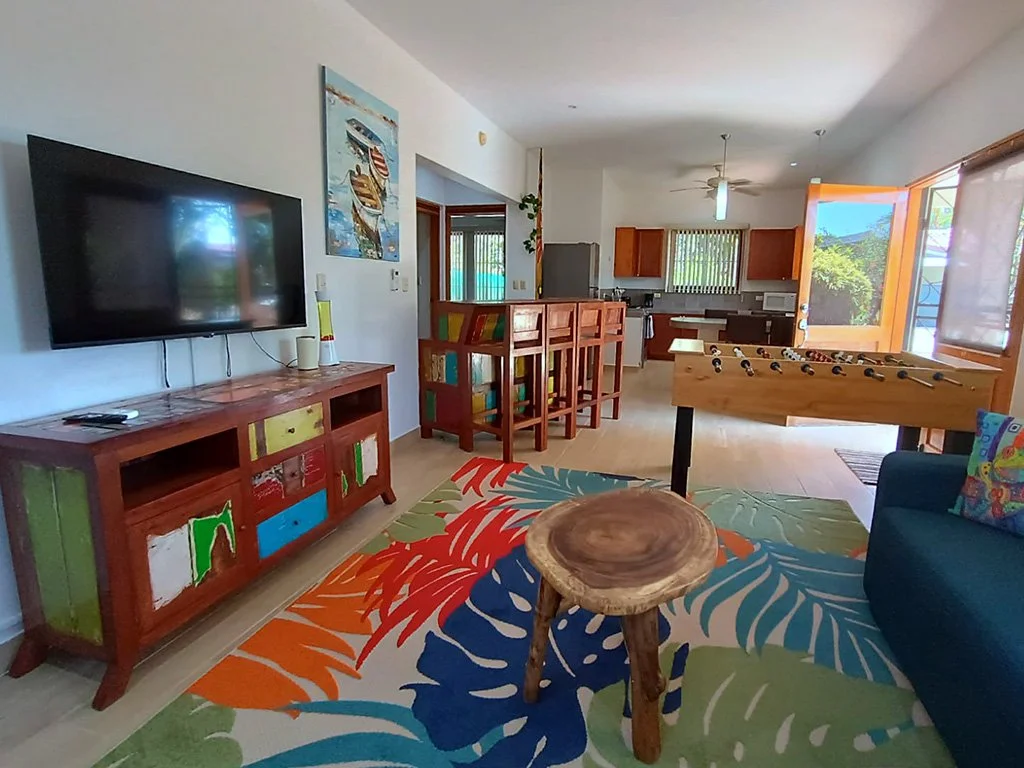 Living room of the lower unit at Hermosa Duplex in Playa Hermosa featuring TV, game table, open social area, and access to the kitchen.