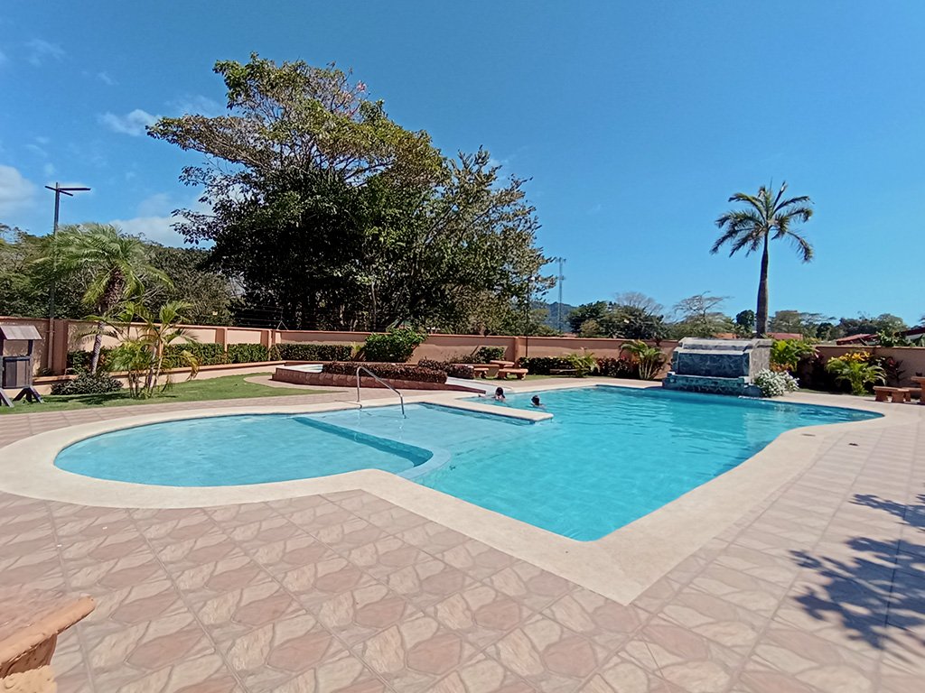 Spacious tropical-style pool with palm trees at Sol Dorado House vacation rental in Costa Rica.