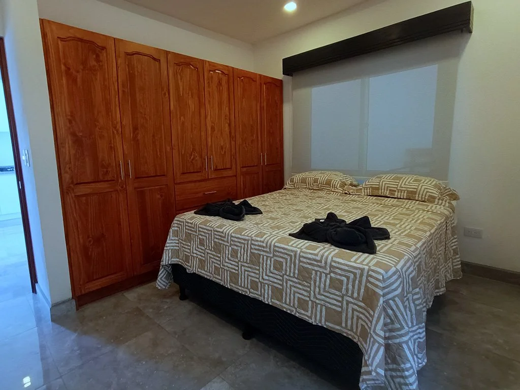 Modern master bedroom with large wardrobe and comfortable bedding at Belford Apartments in Jacó Beach Front, Costa Rica.