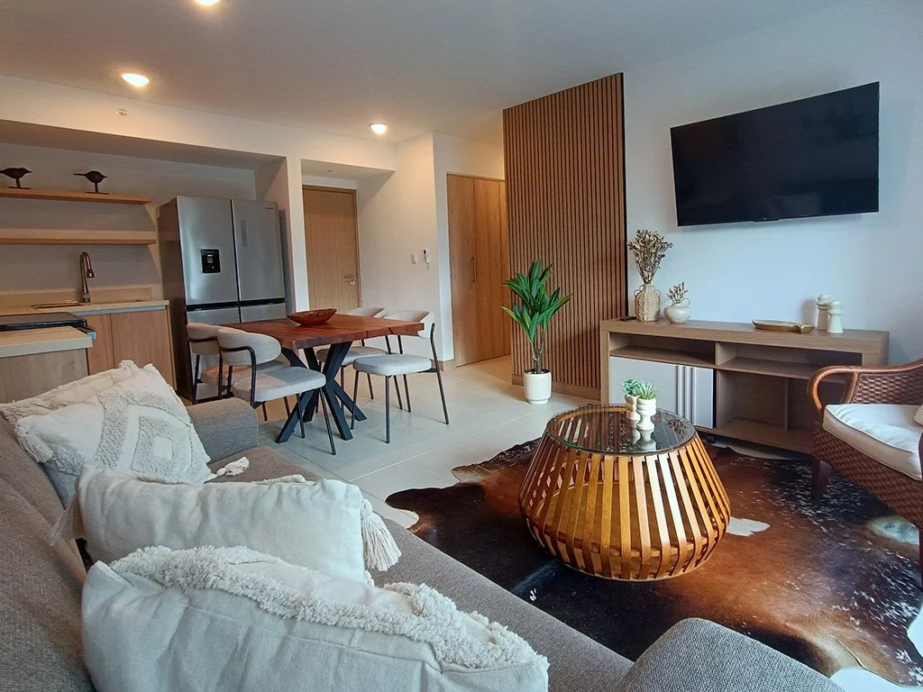 Contemporary open living space with kitchen and dining area at Live Jacó condominium in Jacó, Costa Rica.
