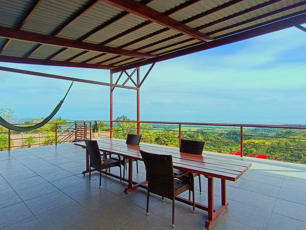 Covered terrace with panoramic ocean and jungle views at Container House in Cerro Fresco, Costa Rica.