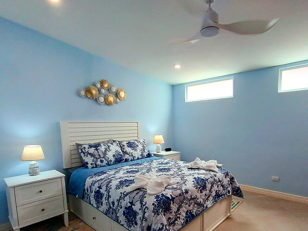 Cozy tropical-style bedroom with comfortable queen bed at Beach apartment COCO 49 vacation rental in Jacó, Costa Rica.