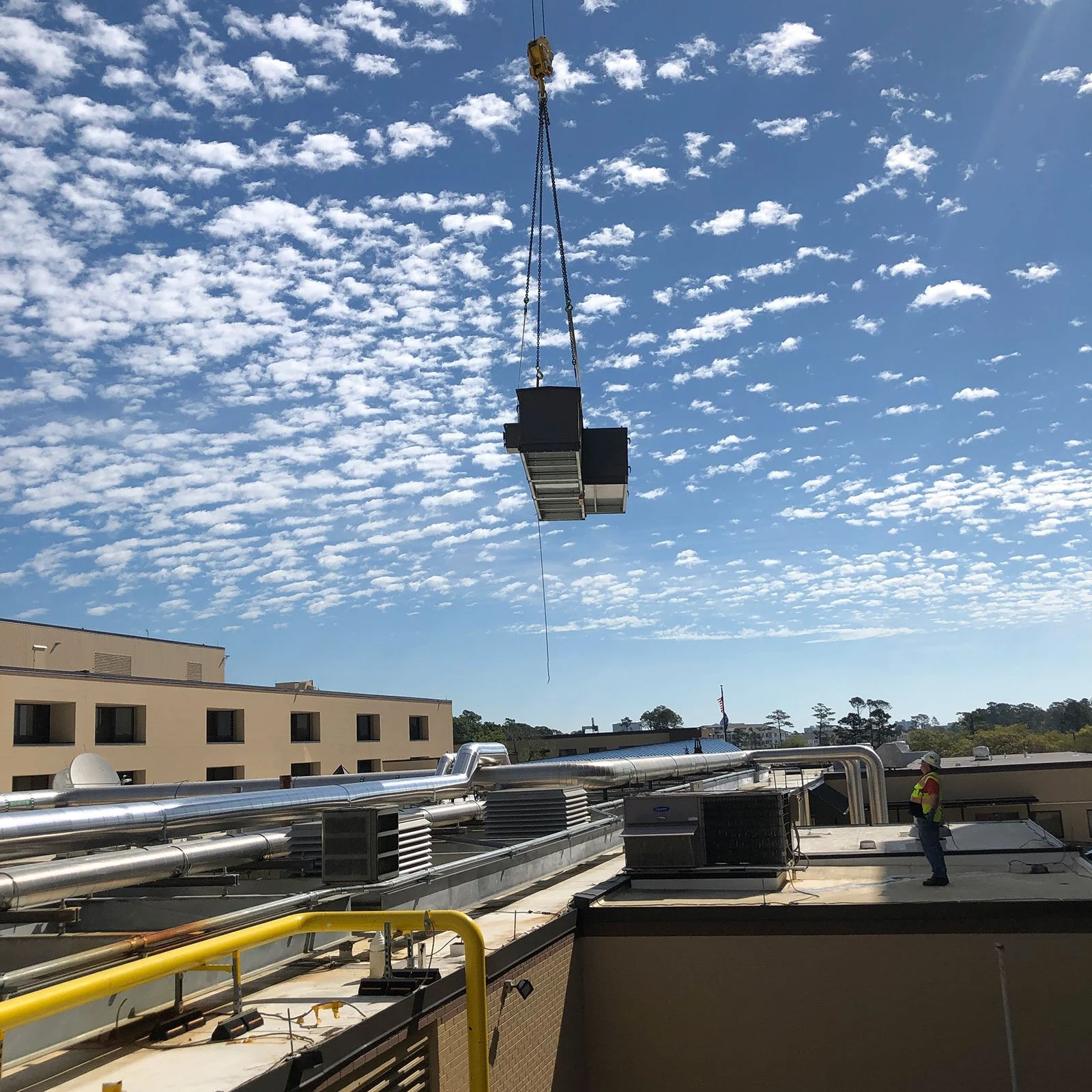 Equipment being moved by crane for installation