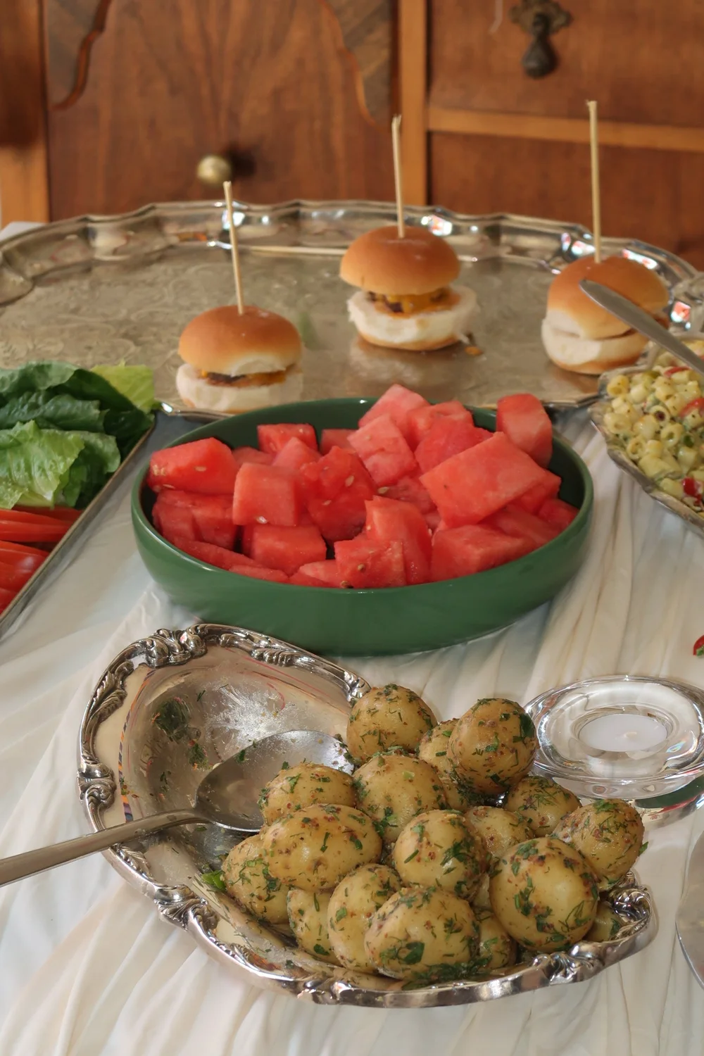 Sliders, watermelon and potatoes on a silver tray