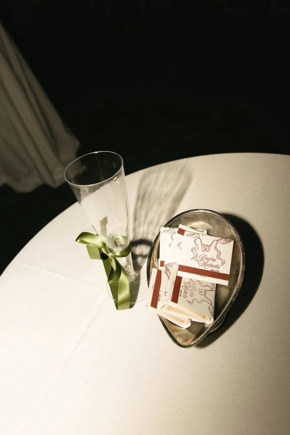A ribboned champagne flute and matchbooks on a cocktail table
