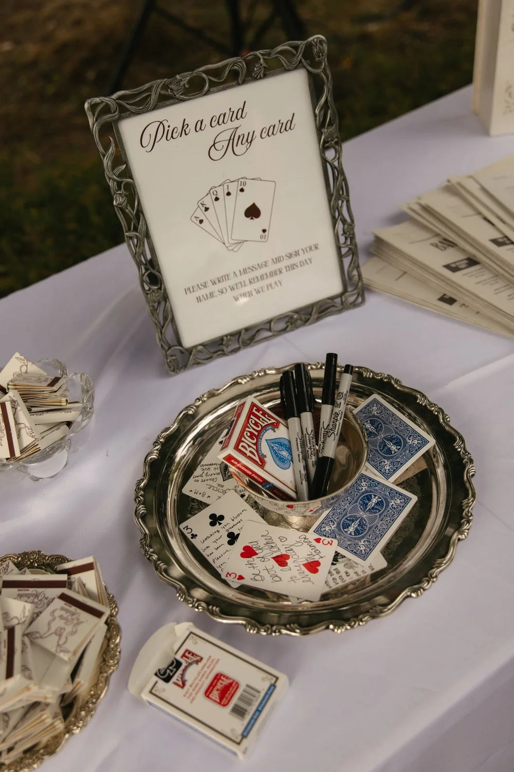A pick-a-card guestbook in a pewter frame on a silver tray