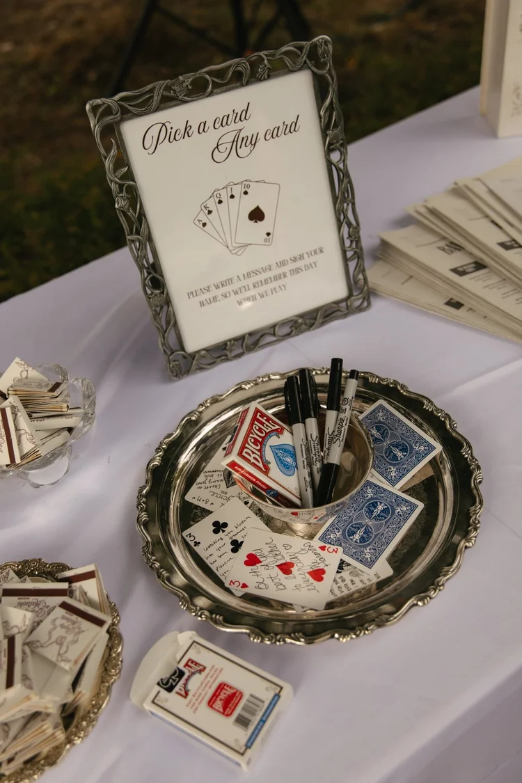 A pick-a-card guestbook in a pewter frame on a silver tray