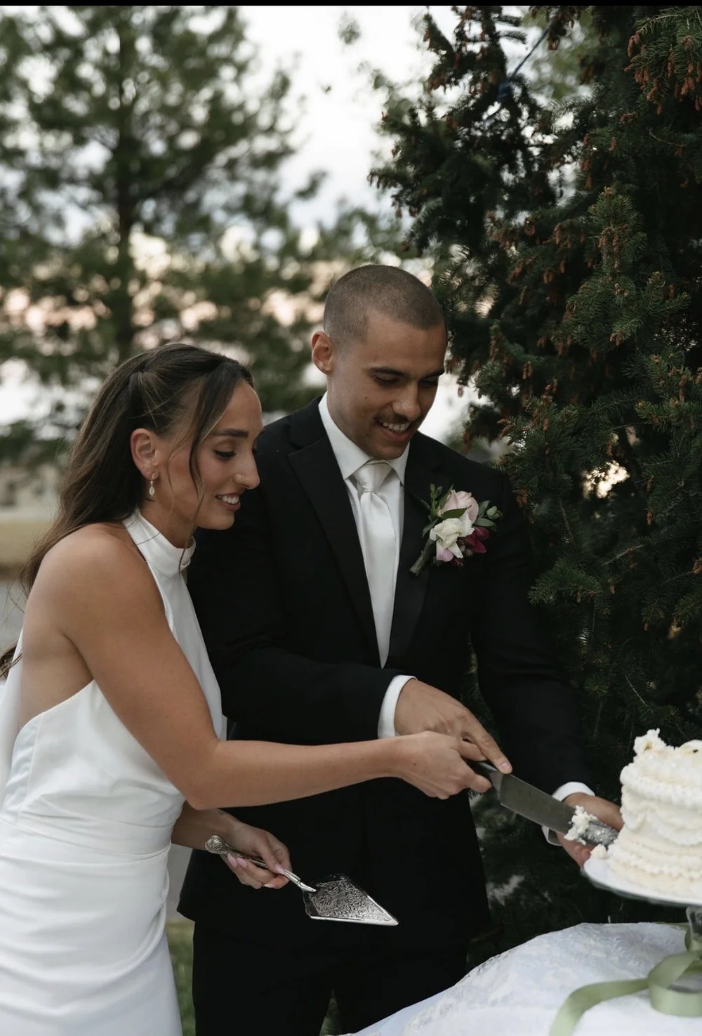 A couple cutting their wedding cake with a vintage cake server