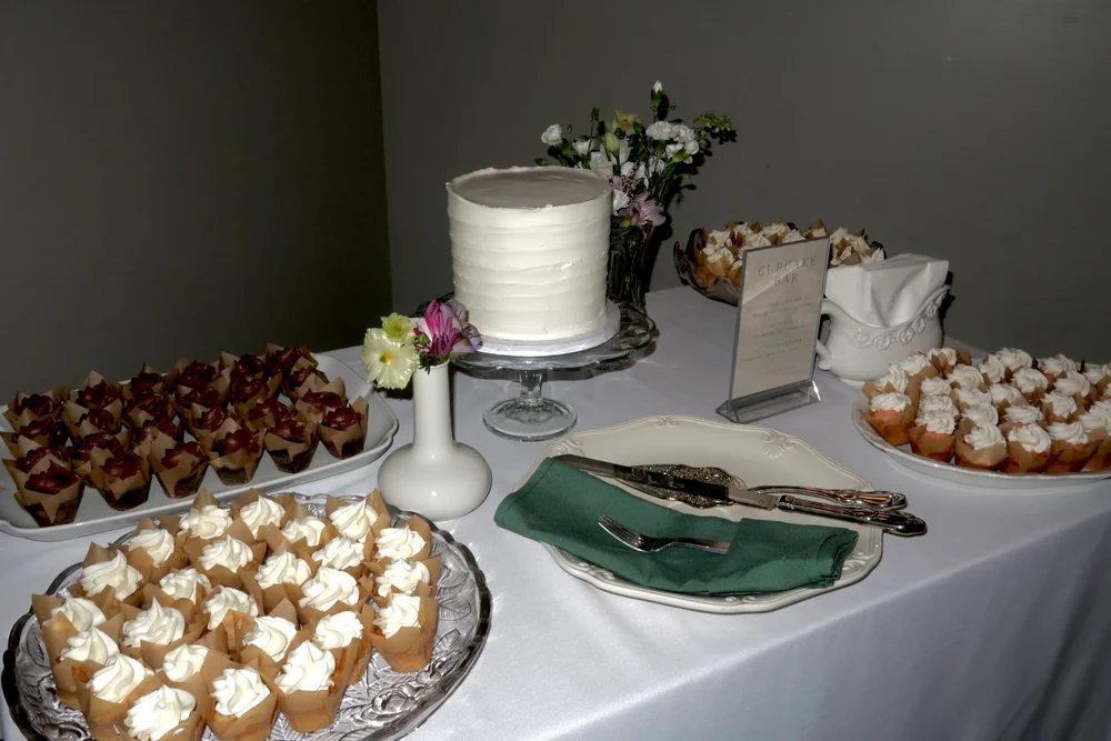 A dessert table with cake, cream puffs and a green napkin
