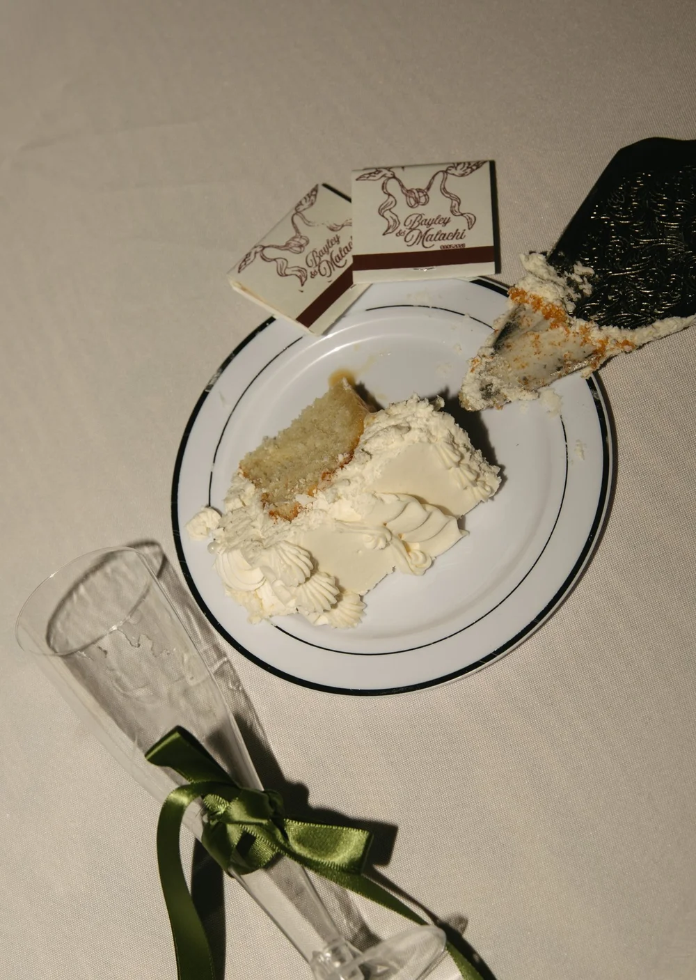 A slice of wedding cake beside custom matchbooks