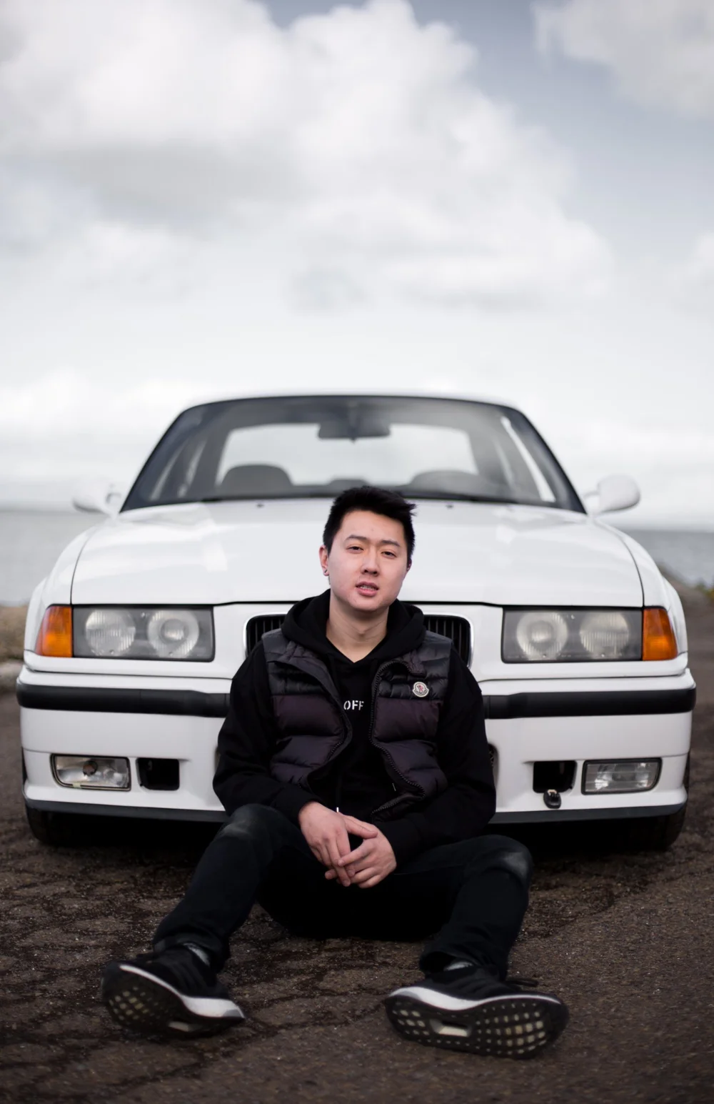 Dominic sitting in front of his white BMW