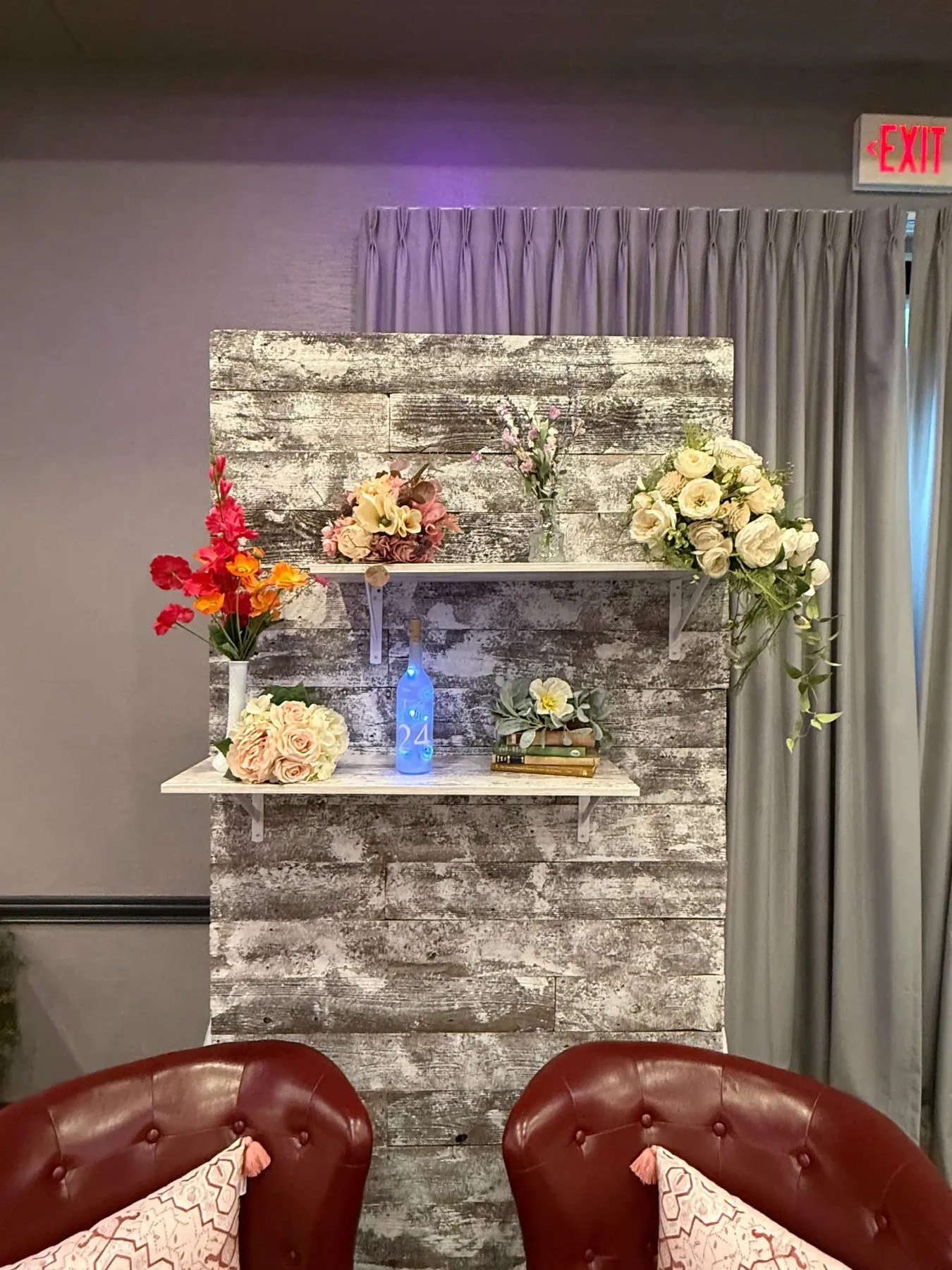 Bouquets and small floral arrangements displayed on shelves against a weathered wood backdrop.