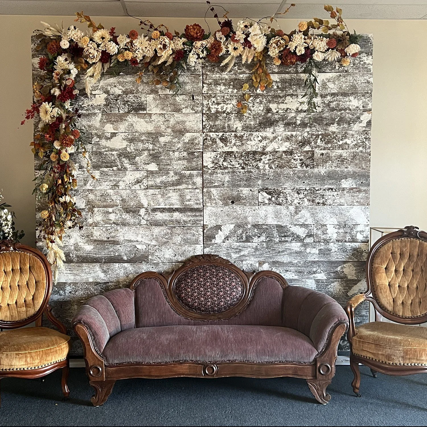 White Barn Wood Wall styled with a floral swag and vintage lounge seating.