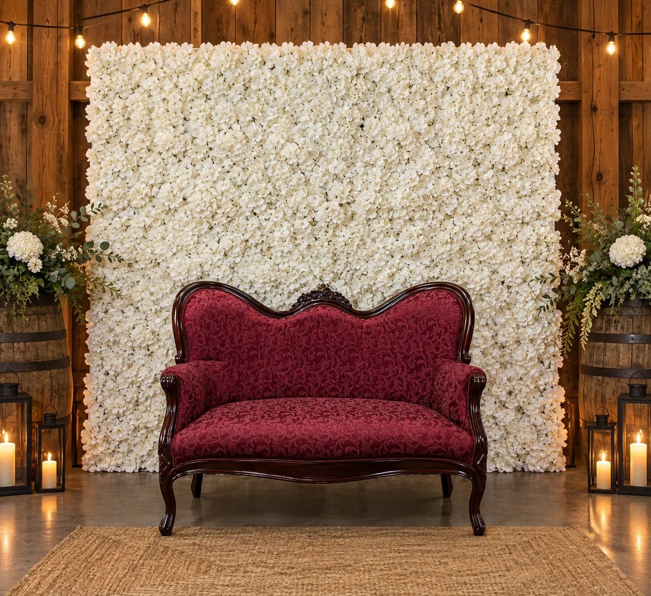 Maroon Love Seat styled with a white floral wall and lanterns.