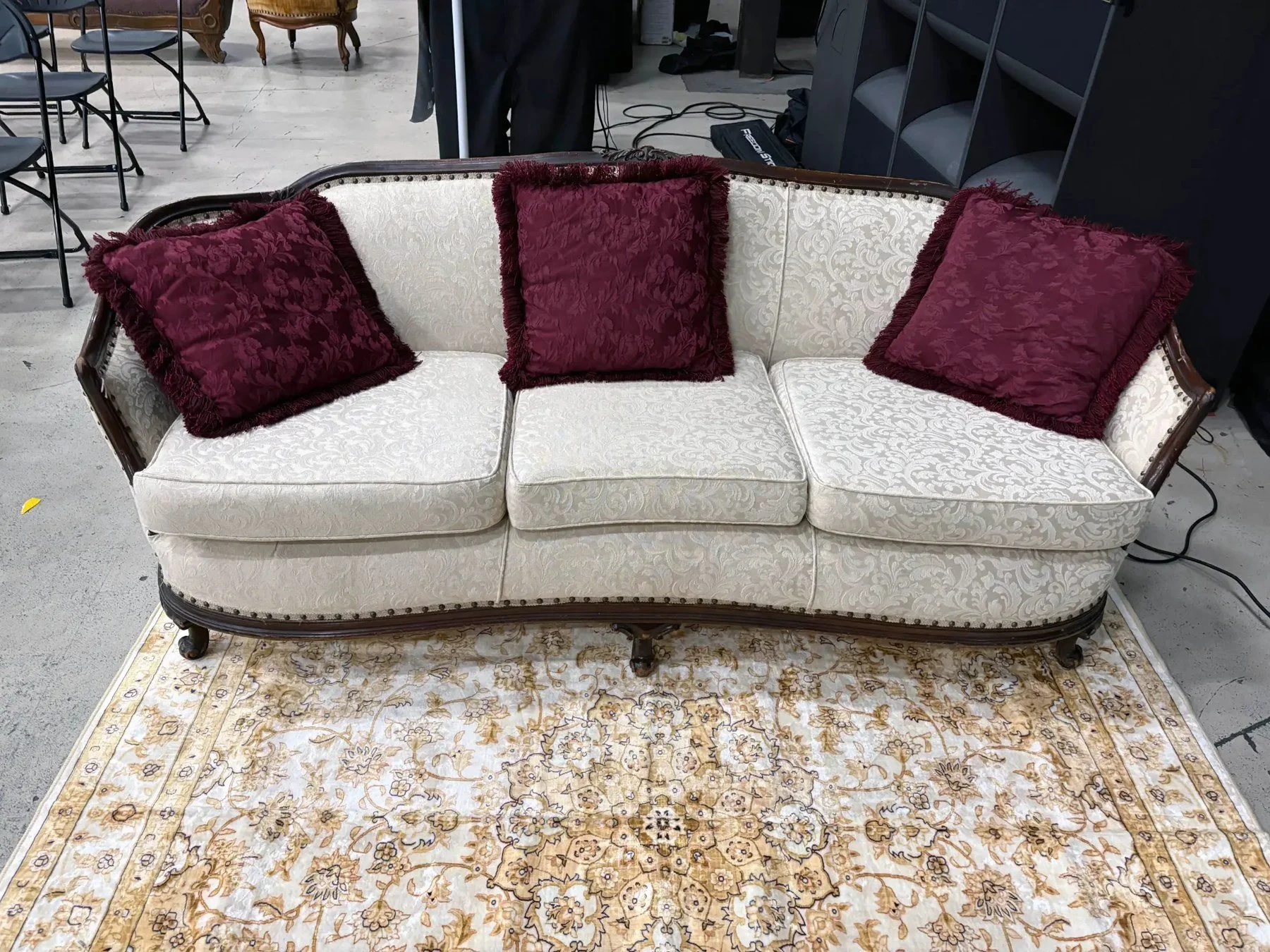 White Vintage Couch with maroon accent pillows.