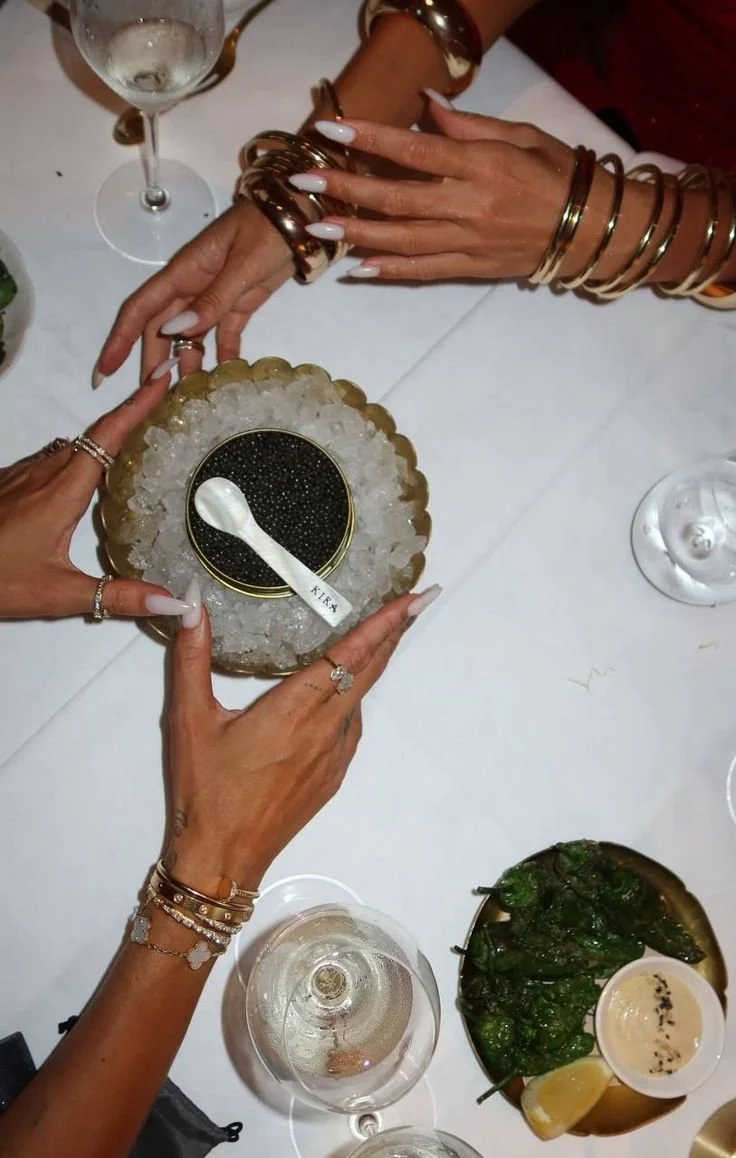 Hands reaching for caviar on ice