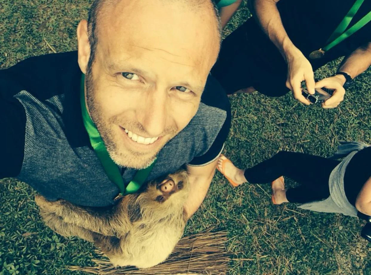 Darren of the Endurance Limits Brazil Jungle Ultra Marathon team at the finish, holding a sloth after completing the adventure race.