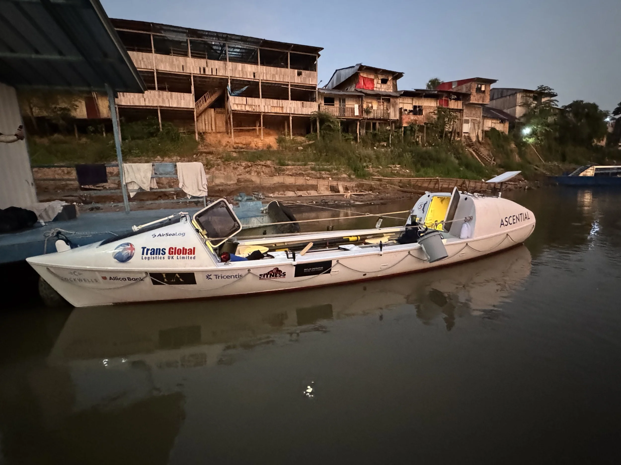 Endurance Limits Amazon Row expedition boat docked at a remote Amazon village along the river.