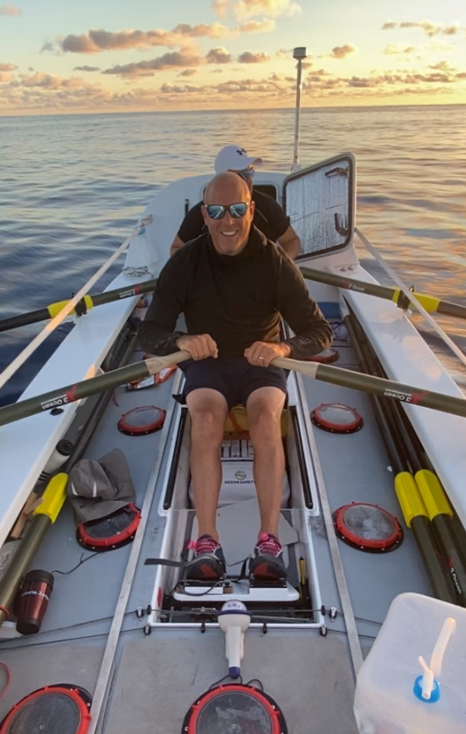 Darren of the Endurance Limits Pacific Ocean Crossing team rowing at sunset during the adventure.