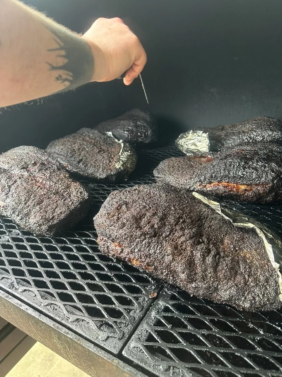 Probing briskets in the smoker