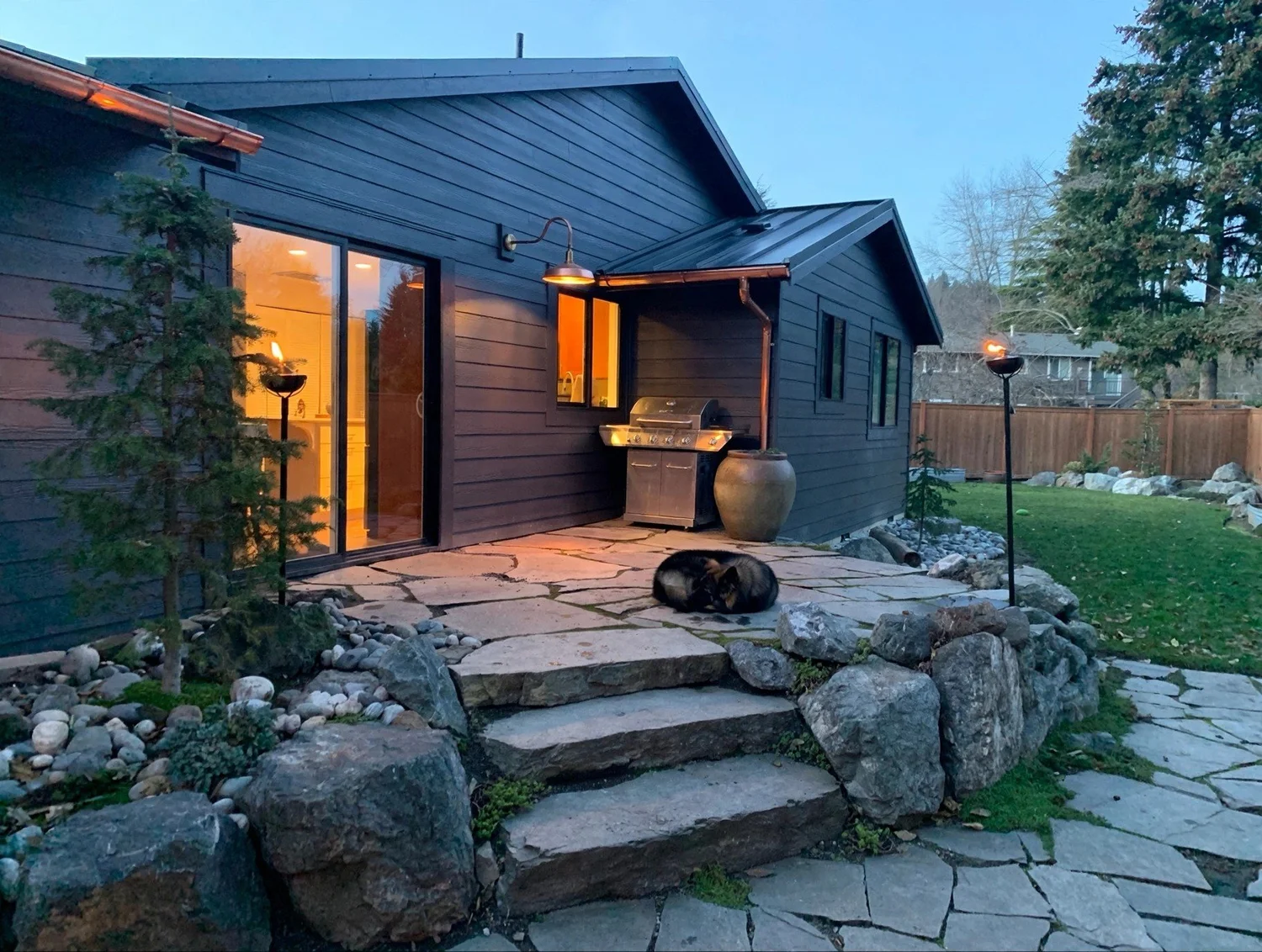 Remodeled Kirkland home rear patio and landscaped yard at dusk