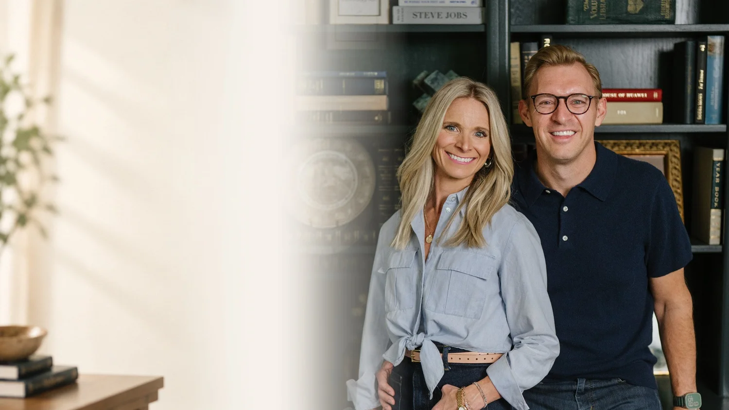 Jon and Ashley Lefrandt smiling together in front of dark bookshelves