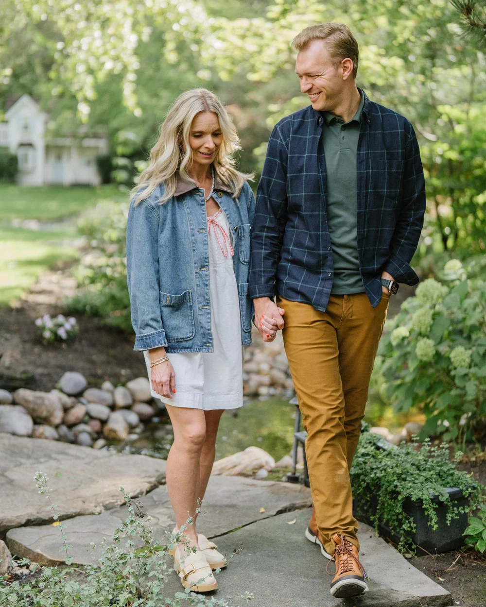 Jon and Ashley Lefrandt walking hand in hand through a garden