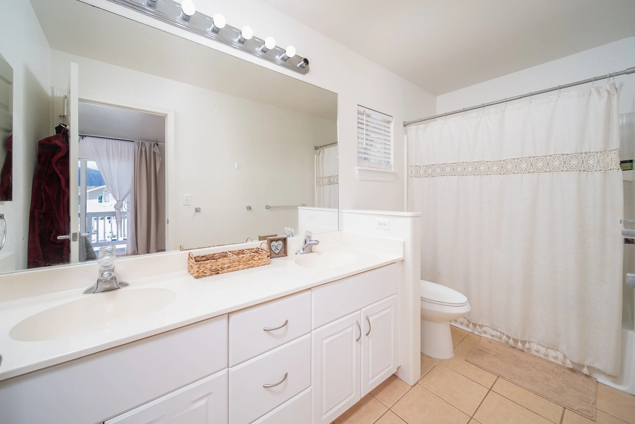 Bathroom with double vanity, wide mirror and shower tub combination