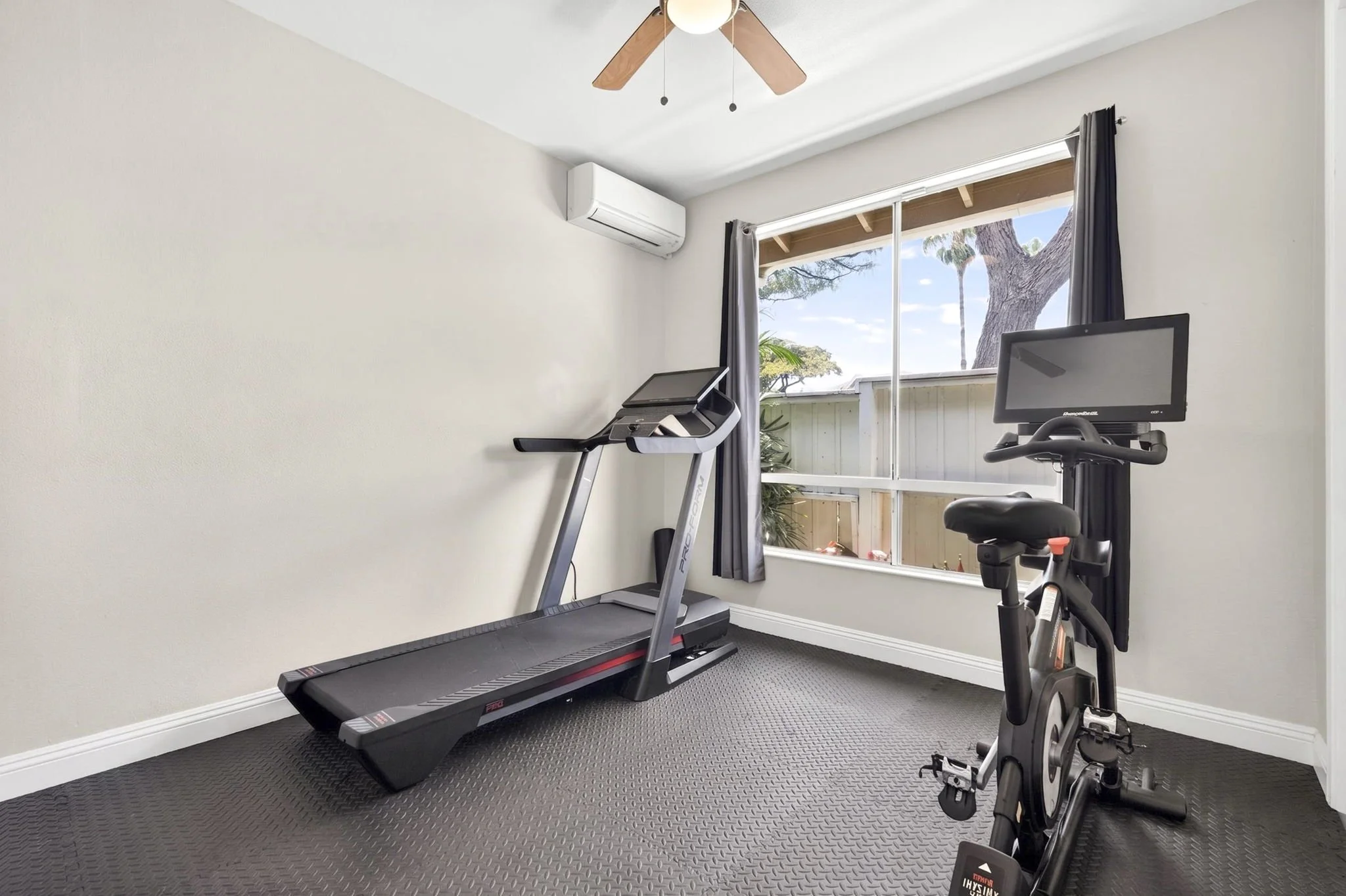 Bonus room set up as a home gym with treadmill and exercise bike