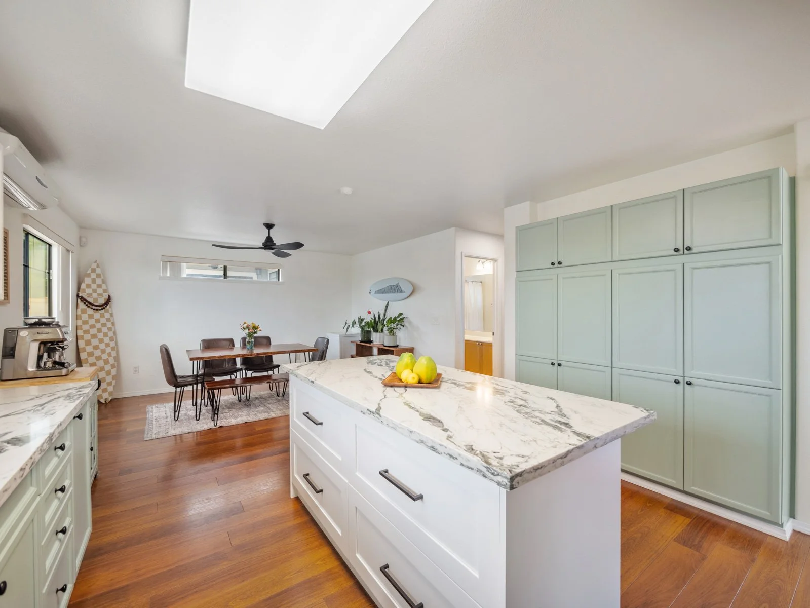 Kitchen with skylight, island seating and dining area beyond