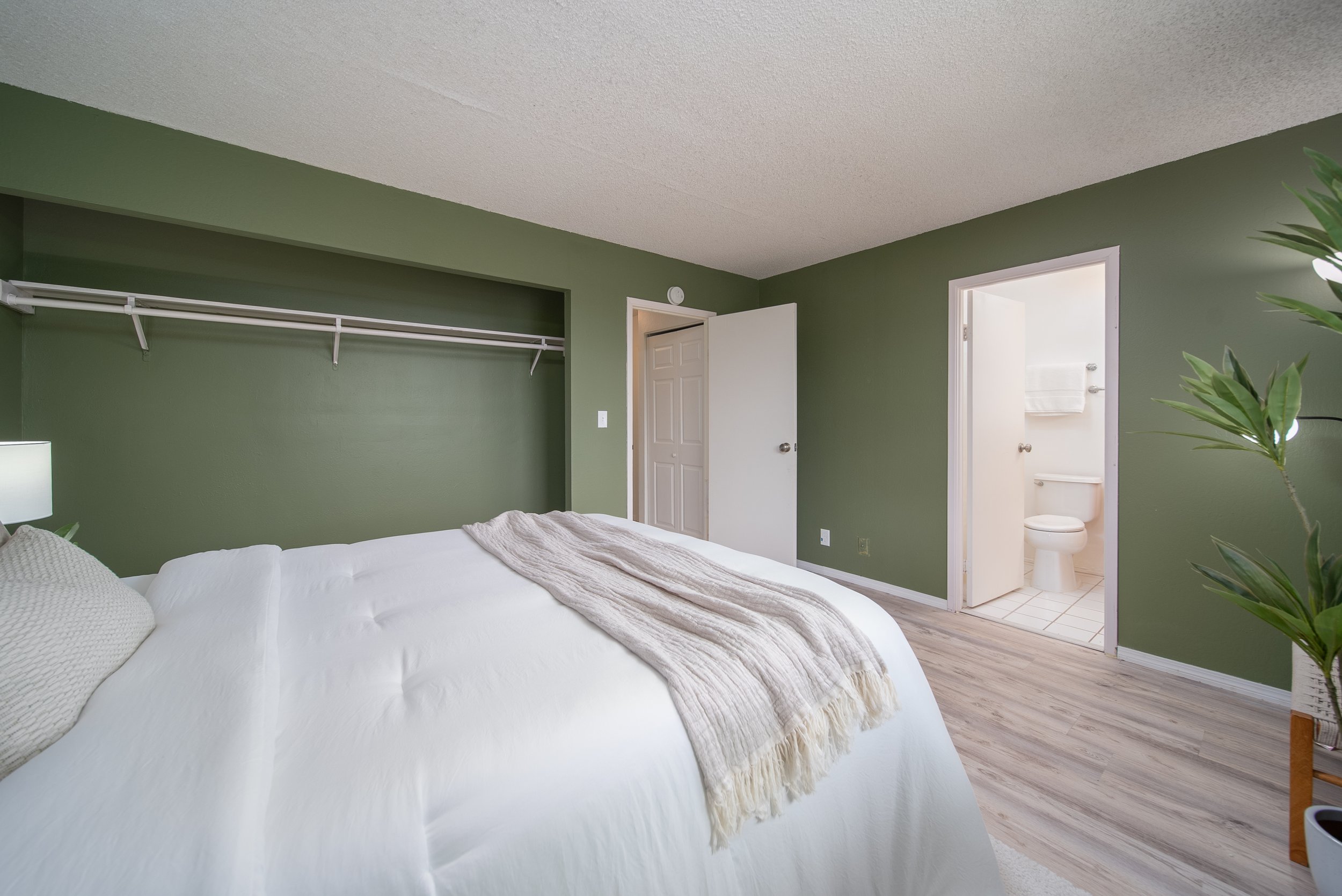 Primary bedroom with closet wall and doorway to the en suite bathroom