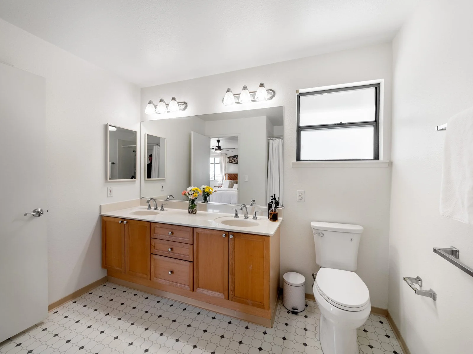 Bathroom with double vanity, wood cabinetry and window above