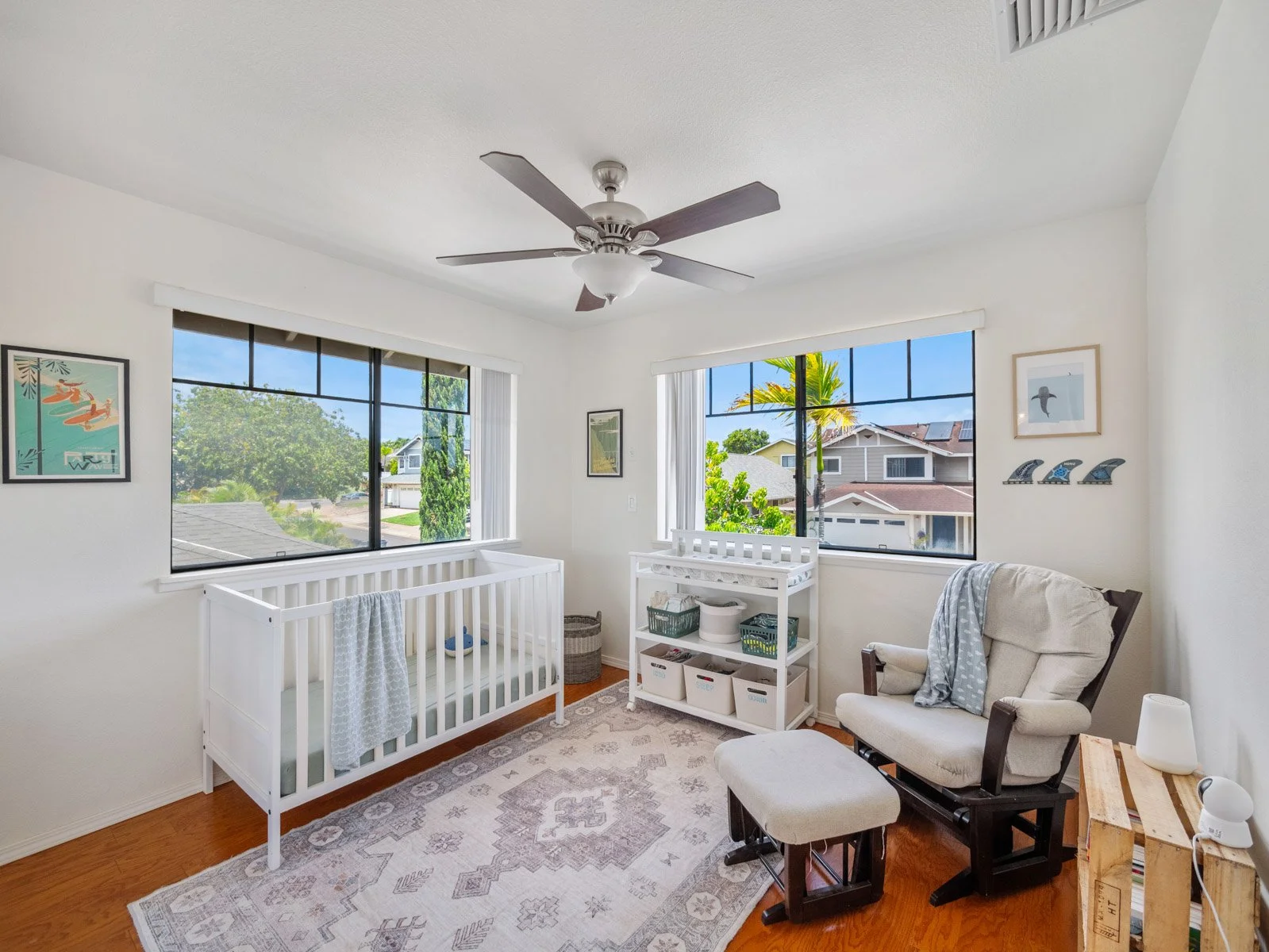 Upstairs bedroom with ceiling fan and two windows to the street