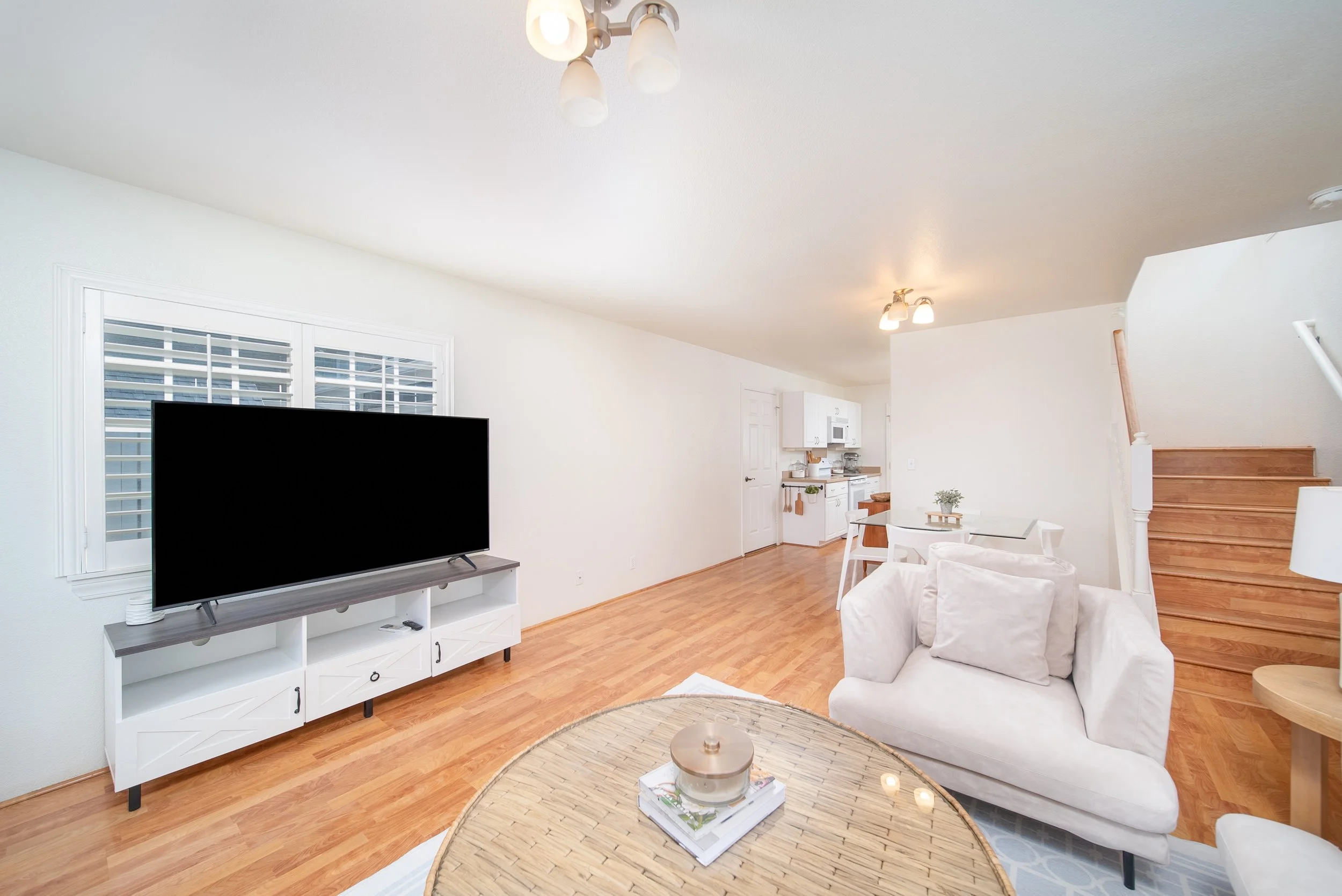 Living and dining area with staircase and natural light throughout
