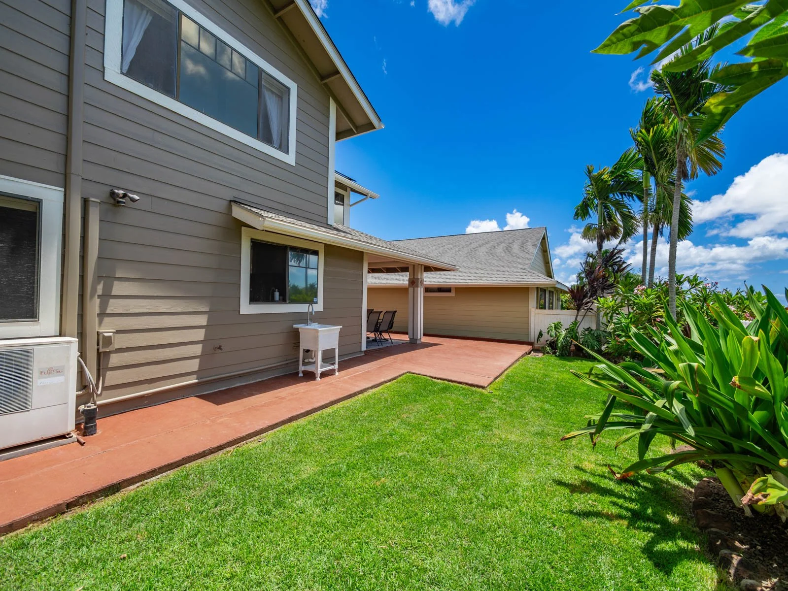 Side yard with lawn, patio walkway and split air conditioning unit