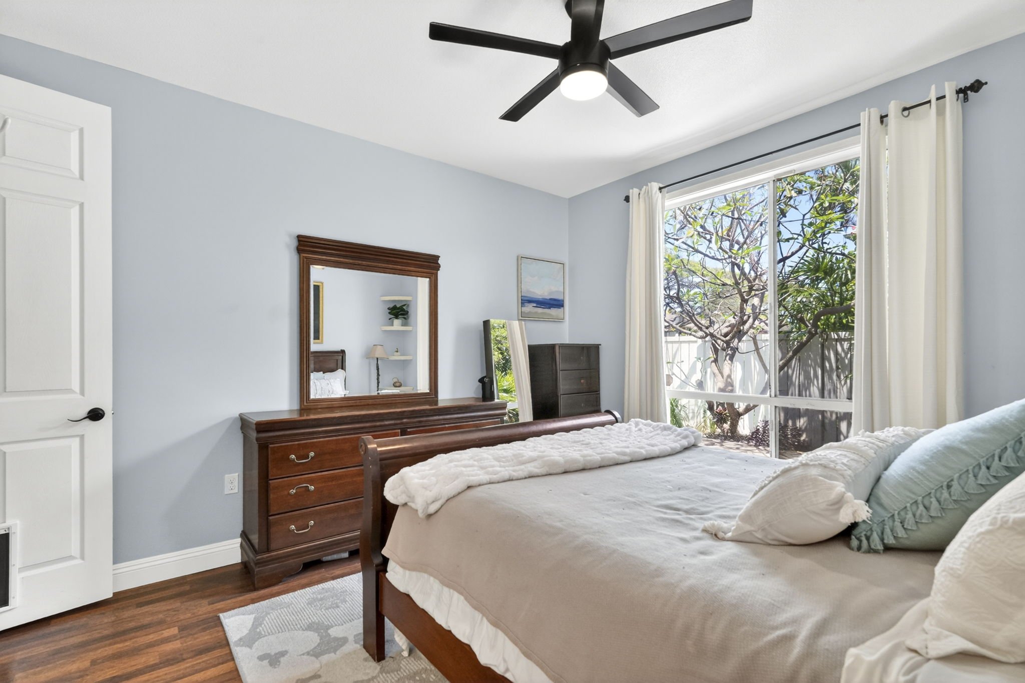 Primary bedroom with ceiling fan and sliding door to the covered porch
