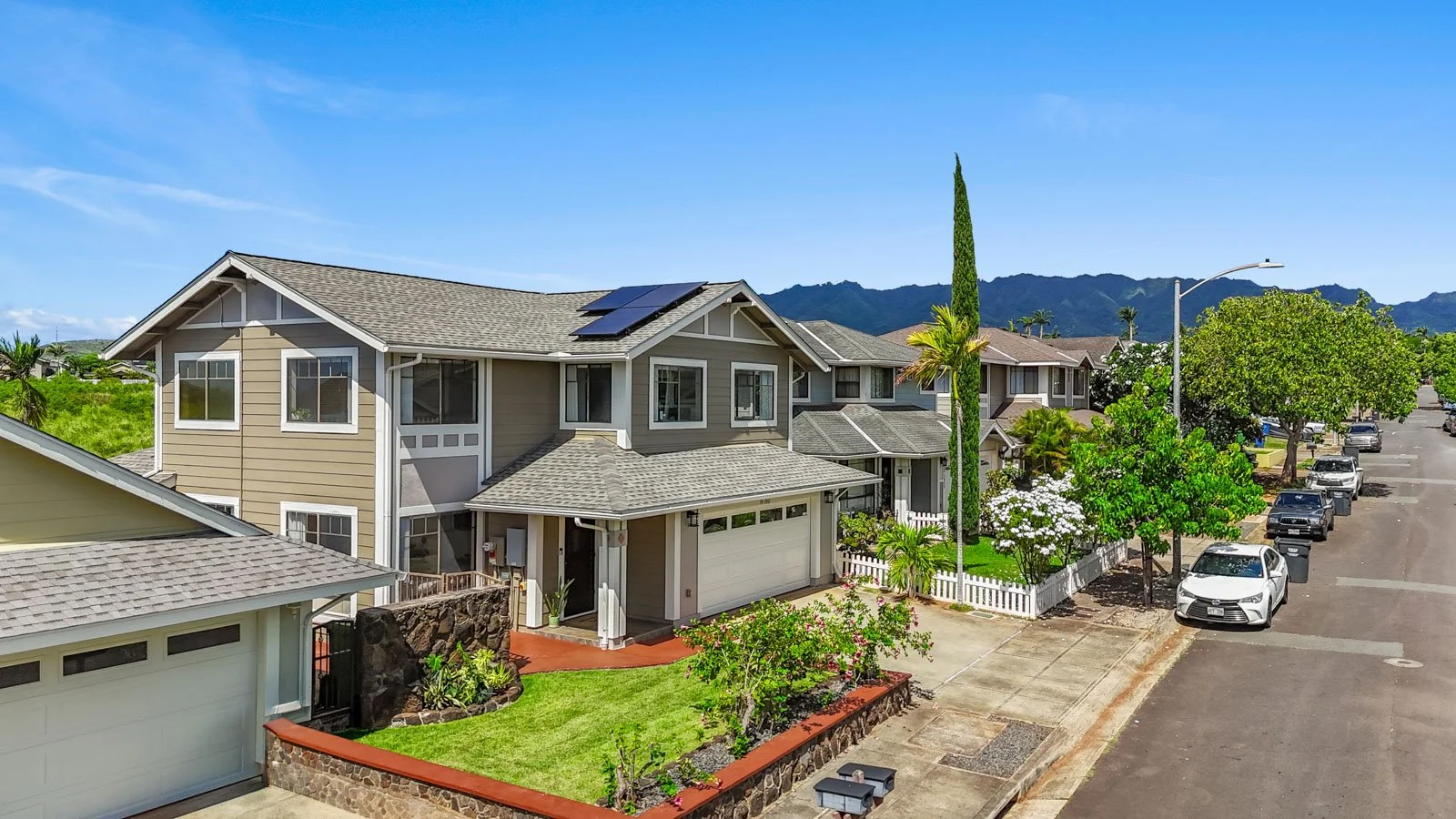Street view of the exterior with rooftop solar panels and mountains beyond